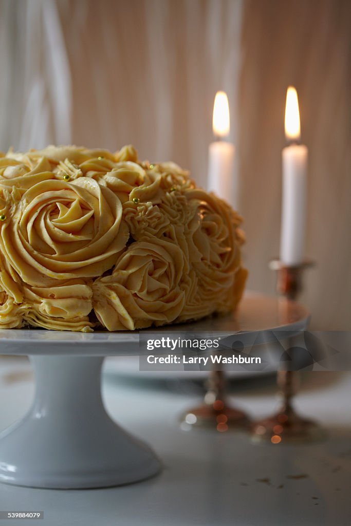 Rose cake and candles on table