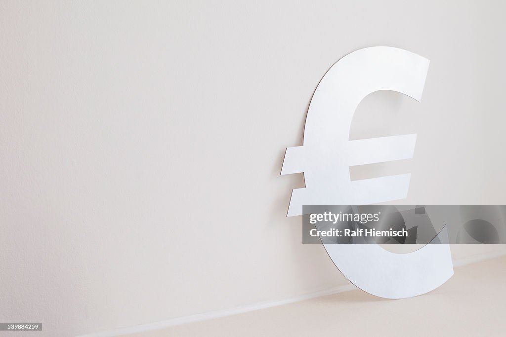 Euro symbol against wall