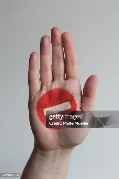 close-up of stop sign painted on mans hand against gray background - denied stock pictures, royalty-free photos & images