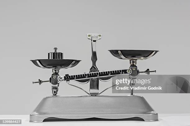 old-fashioned weight on weighing scale against gray background - balance photos et images de collection