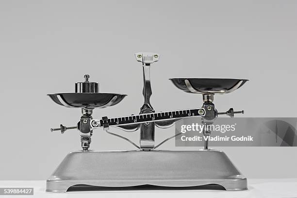 old-fashioned weight on weighing scale against gray background - balansvåg bildbanksfoton och bilder