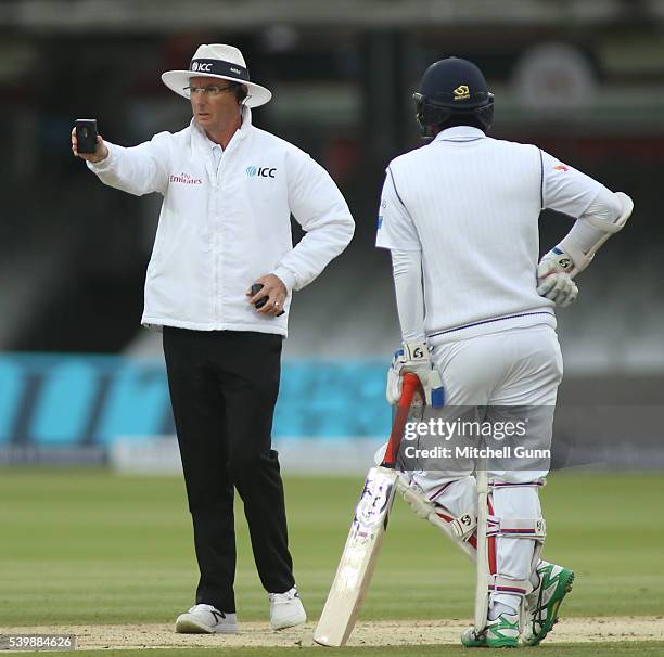 Umpire Rod Tucker takes a light meter reading during day five of the 3rd Investec Test match between England and Sri Lanka at Lords Cricket Ground on...