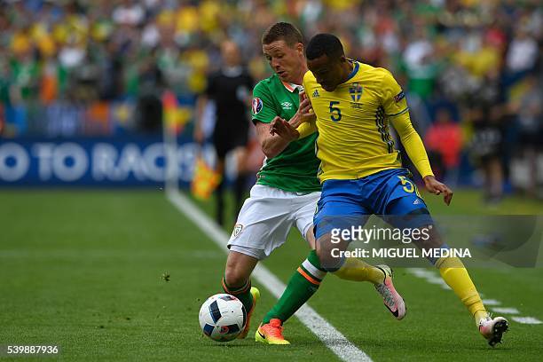 Sweden's defender Martin Olsson and Ireland's midfielder James McCarthy vie for the ball during the Euro 2016 group E football match between Ireland...