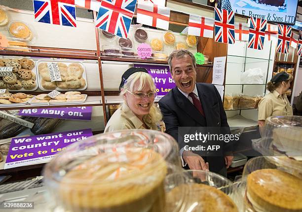 Independence Party leader Nigel Farage leader poses with a worker at a bakery in Sittingbourne as he campaigns for Brexit on June 13, 2016. Britain's...