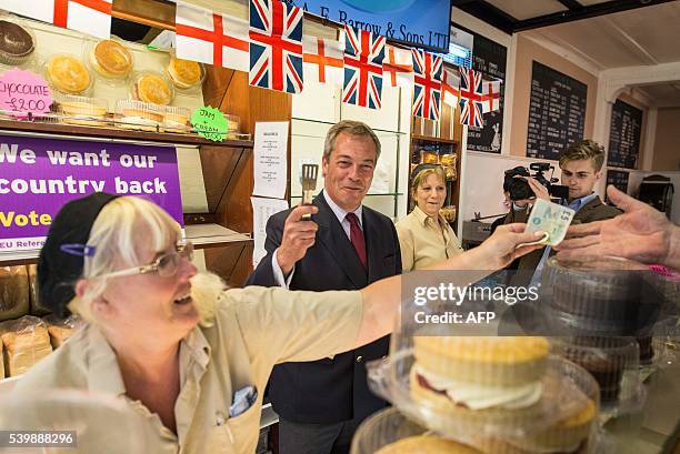 Independence Party leader Nigel Farage poses behind the counter of a bakery in Sittingbourne as he campaigns for Brexit on June 13, 2016. Britain's...