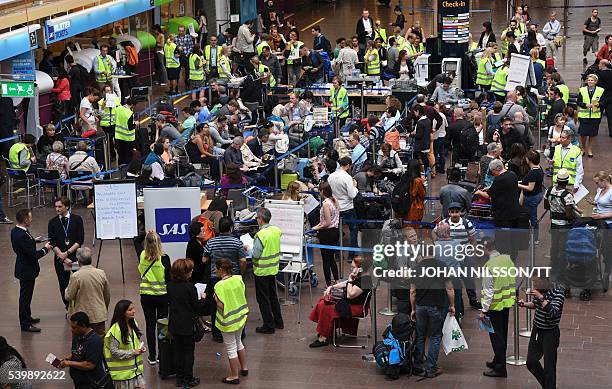 Passengers wait in line to be rebooked at the SAS ticket counter at Arlanda airport north of Stockholm, Sweden, June 13, 2016. SAS cancelled 230...