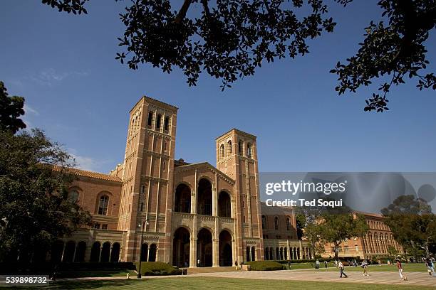 View of the facade of Royce Hall with students walking on the grounds of the UCLA College Campus.