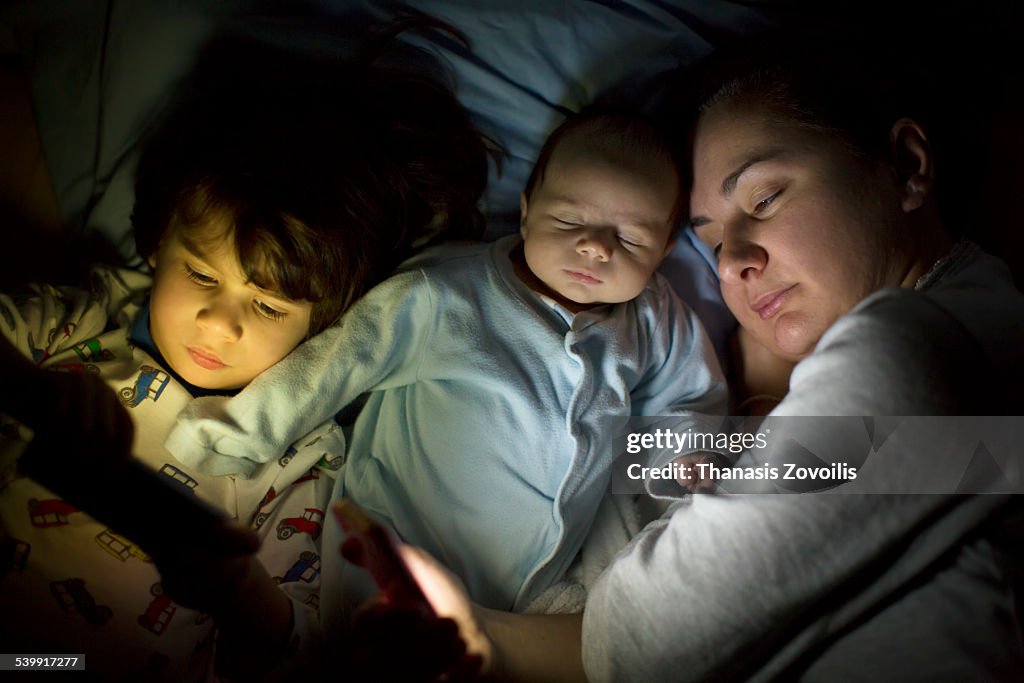 Mother with her kids using digital devices