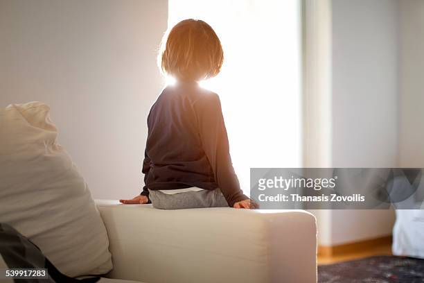 portrait of a small boy - behind window stock-fotos und bilder