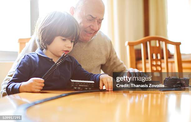 grandfather playing with his grandson - miniature train stock pictures, royalty-free photos & images