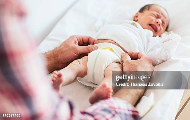 father with his newborn child - nappy change stockfoto's en -beelden