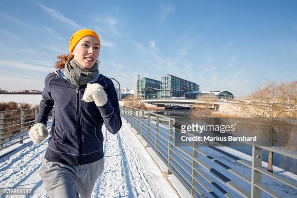 woman jogging in winter - winter sport stock-fotos und bilder