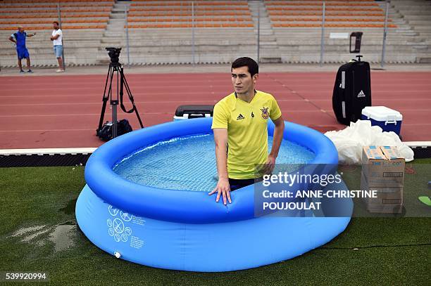 Ukraine's midfielder Taras Stepanenko kneels in an inflatable pool of cold water as recovery therapy during a training session at the Carcassonne...