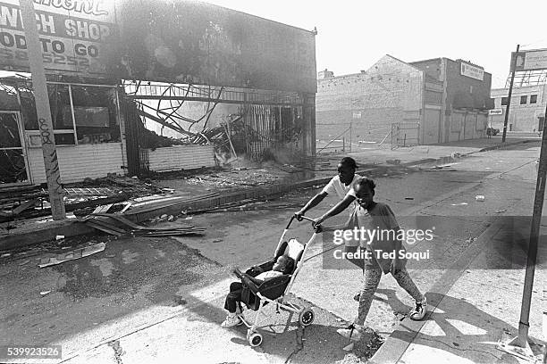 Woman with her children walk past several burn out businesses on South Vermont Ave. In South Central Los Angeles. Los Angeles has undergone several...