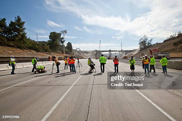 Local media rush on to the 405 freeway to do newscast and photographs. Carmageddon 2 in Los Angeles. Construction crews demolish the Mulholland...