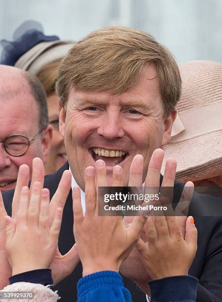 King Willem-Alexander of The Netherlands gives high fives to school children after his visit to the sustainable tomato producer Empatec during their...