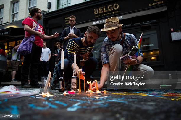People light candles during a vigil for the victims of the Orlando nightclub shooting, on Old Compton Street, Soho on June 13, 2016 in London,...