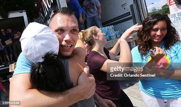 Brandon Williams and Christie Cruz embrace after volunteers at the GLBT Community Center of Central Florida loaded trucks with 750 cases of water on...