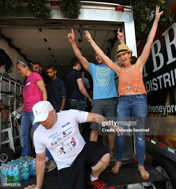 Brandon Williams and Crystal Fitzgerald cheer after volunteers at the GLBT Community Center of Central Florida loaded trucks with 750 cases of water...