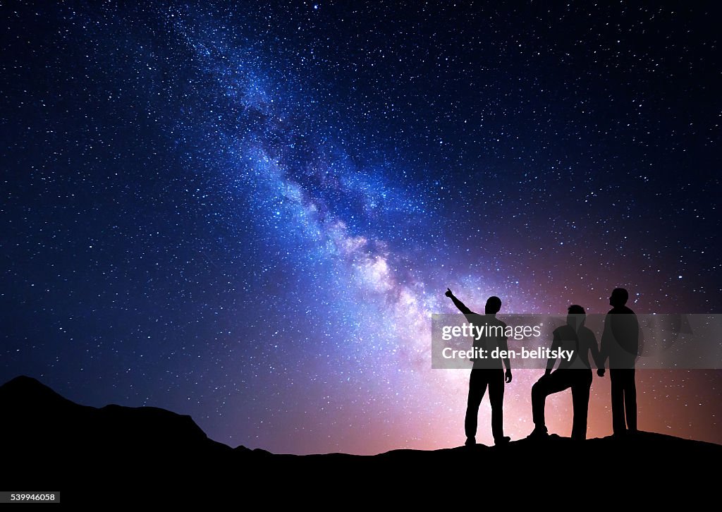 Colorful Milky Way with silhouette of a family