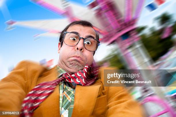 a sick man in a fairground carousel - vertigine foto e immagini stock