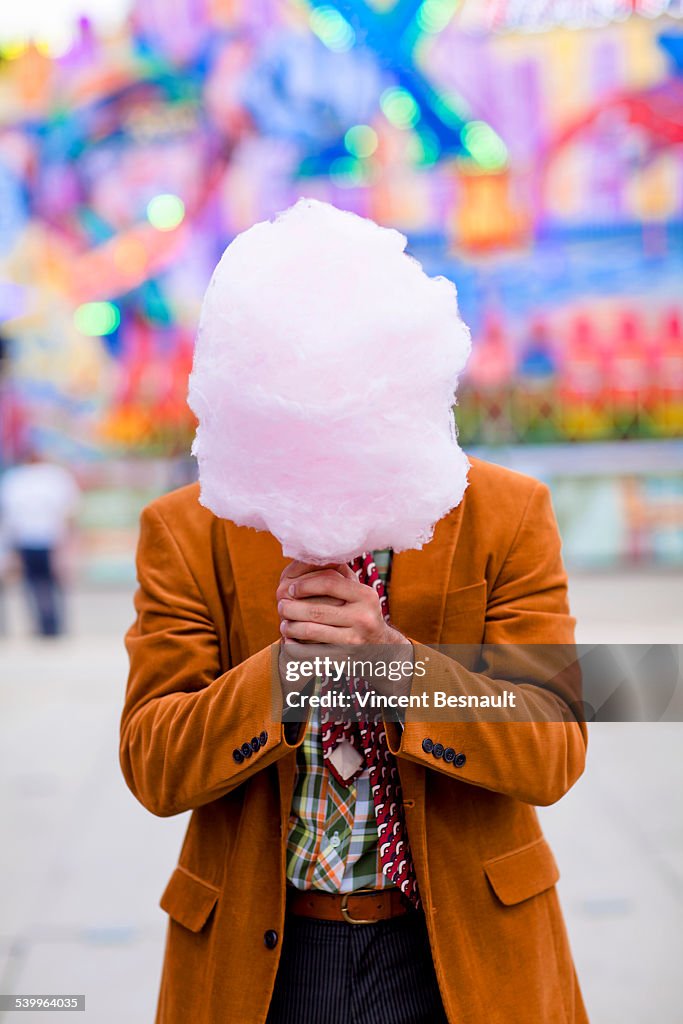 Man holding a cotton candy at the carnival
