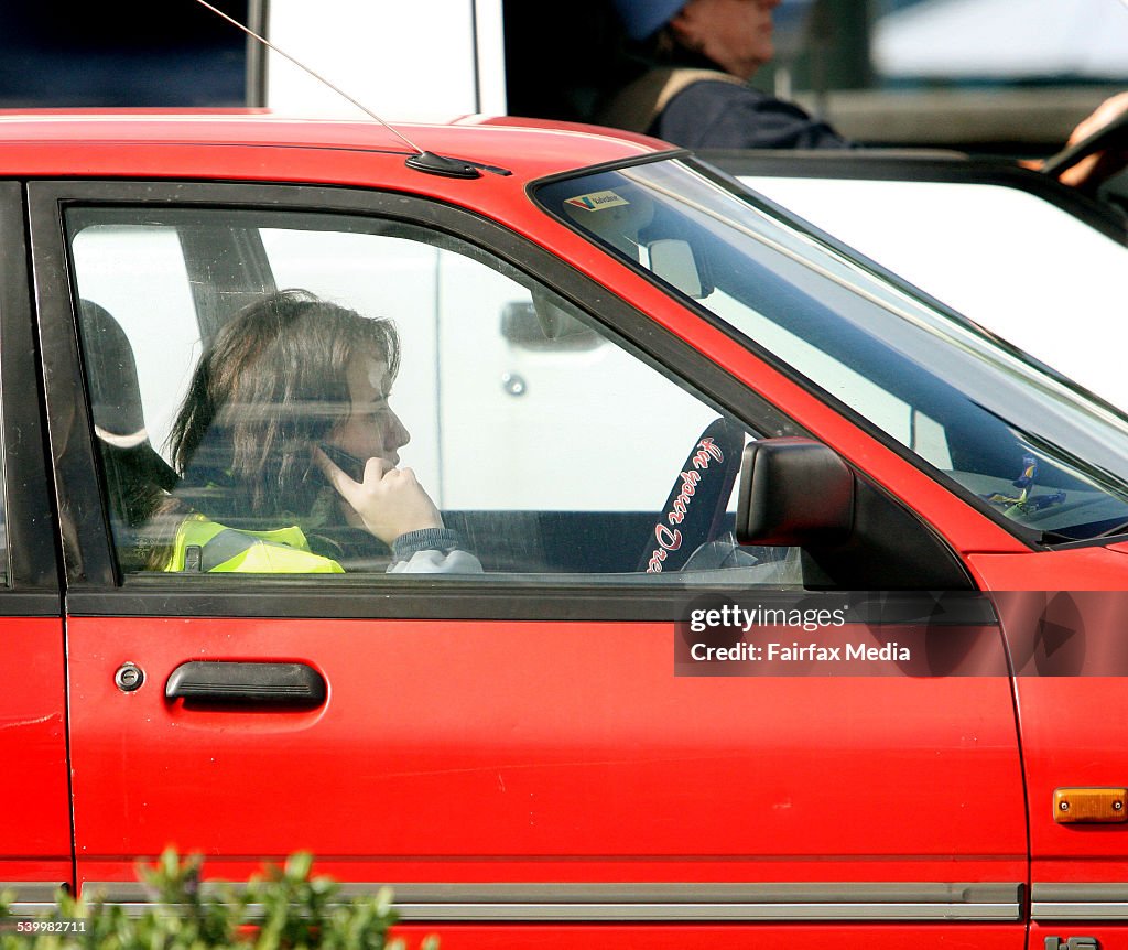 Motorists talking on mobile phones while driving in traffic at Campbell Parade,