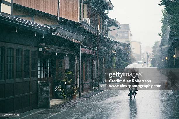 bicycle in the rain, takayama's old streets - heavy rain ストックフォトと画像