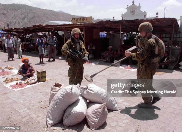 Australian INTERFET troops search the Dili market with a metal detector for dangerous items, East Timor, 26 October 1999. SMH Picture by ANDREW MEARES