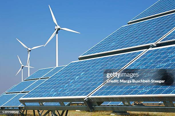 solar panels and wind turbines - umweltfreundliche energieerzeugung stock-fotos und bilder