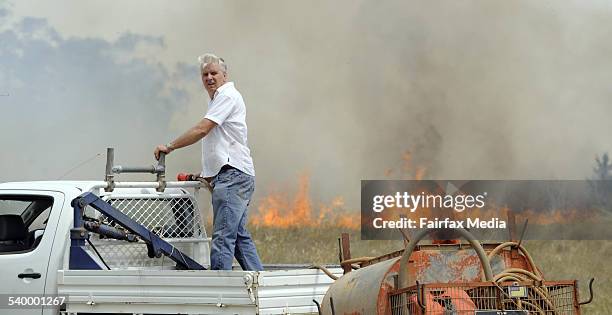 Neil Snape of Kamilaroi Road at Gunnedah protects his property from an approaching fire. The blaze came within five metres of his woolshed where his...