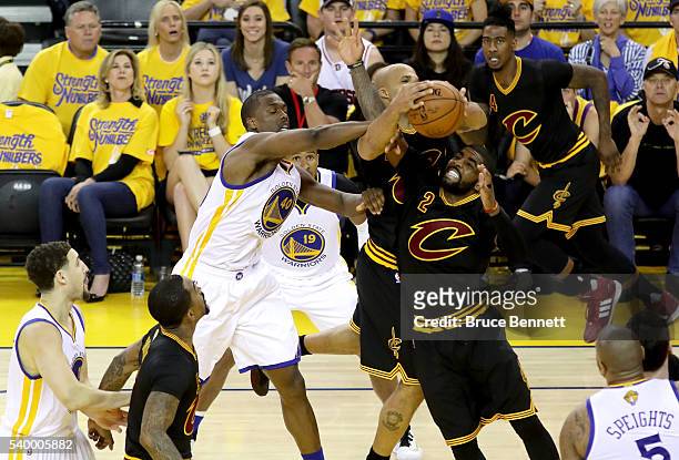 Richard Jefferson and Kyrie Irving of the Cleveland Cavaliers fight for the rebound against Harrison Barnes of the Golden State Warriors during the...