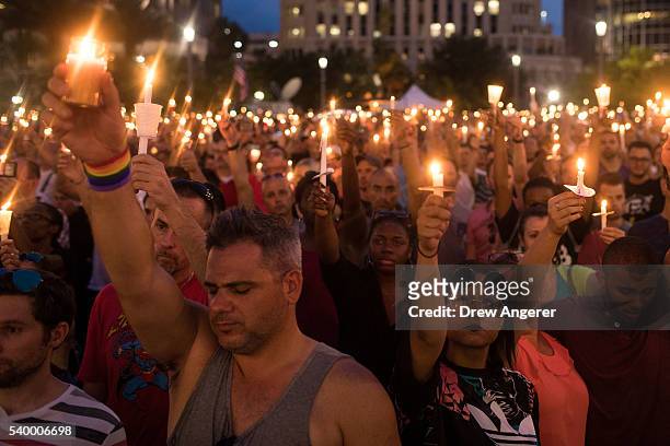 People hold candles during an evening memorial service for the victims of the Pulse Nightclub shootings, at the Dr. Phillips Center for the...