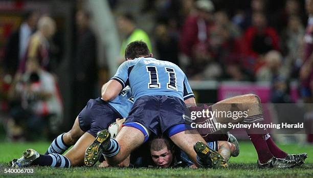 S Andrew Ryan and Steve Simpson land on top of a tackle with Mark O'Meley on the bottom during game 2 of the State of Origin rugby league series...