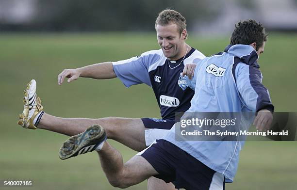 Blues' players Mark Gasnier and Danny Buderus stretch during a training session at Randwick Army Barracks ahead of the second State of Origin match,...