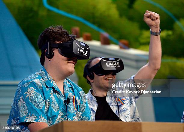 Palmer Luckey, co-founder of Oculus VR Inc., left, plays the new video game "Eagle Flight VR" during an Ubisoft news conference before the start of...