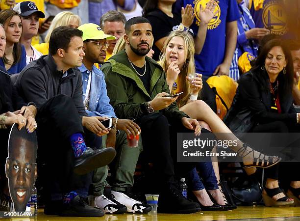 Rapper Drake sits courtside as the Golden State Warriors take on the Cleveland Cavaliers in Game 5 of the 2016 NBA Finals at ORACLE Arena on June 13,...