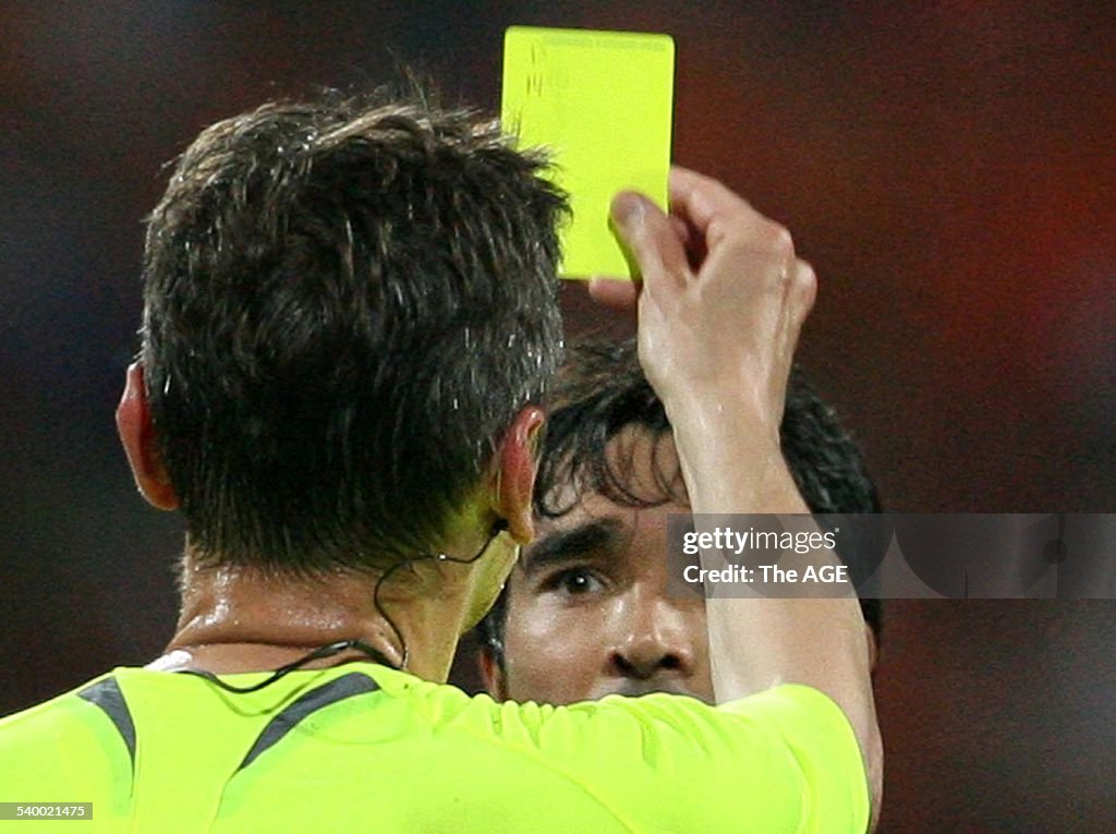 Referee Valentin Ivanov (L) shows Portuguese Deco the yellow card during the Wor