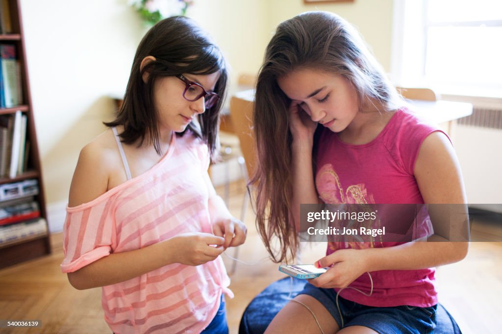 Teen girls indoors listening to music