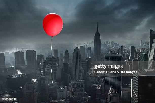red balloon over a gray city - red string stock pictures, royalty-free photos & images