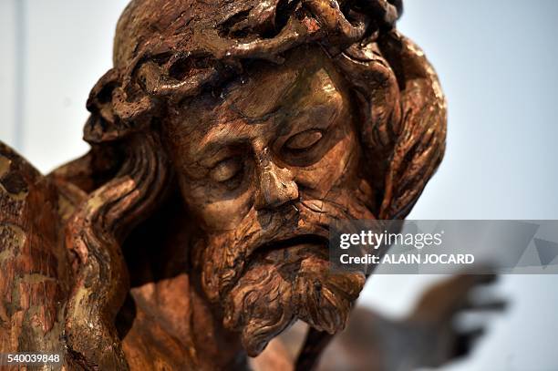 This picture taken on June 13, 2016 in Paris, shows a wooden christ from the 15th century. A masterpiece of the Ottonian art , a golden cross with...