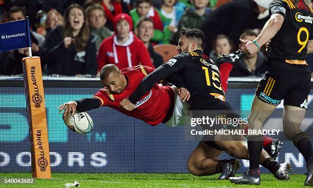 Eli Walker of Wales is tackled short of the line by Waikato Chiefs player James Lowe during the rugby union match between the Super Rugby team...