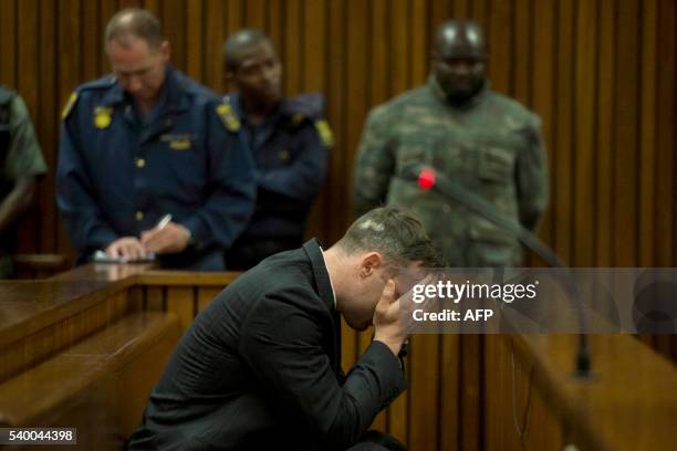 South African Paralympian Oscar Pistorius covers his eyes as the father of his late girlfriend testifies at the Pretoria High Court on June 14, 2016...