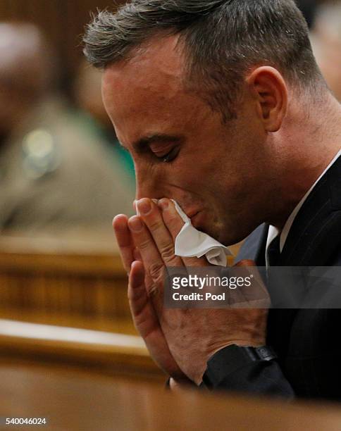 Oscar Pistorius cries as he sits inside the dock at the high court in Pretoria for his sentencing hearing at the high court in Pretoria on June 14,...