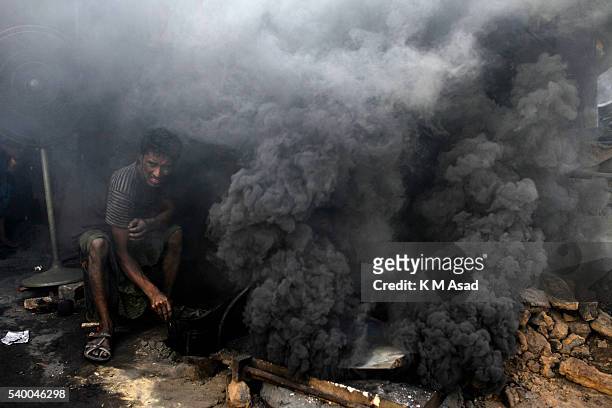 Worker works in the middle of the smoke at a ship propeller making factory in sadarghat dockyard, Dhaka Bangladesg, June 02, 2016. The laborers work...