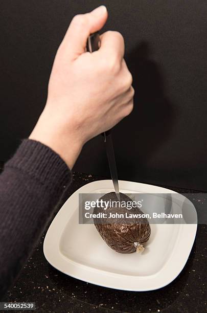 plunging a knife into a haggis - knife splash stock-fotos und bilder