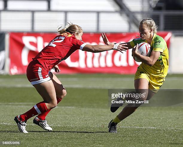 Emma Tonegato of Australia gives a stiff arm block to Kayla Moleschi of Canada during the match at Fifth Third Bank Stadium on April 9, 2016 in...