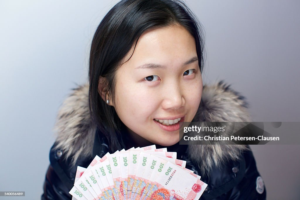 Young Chinese woman holding Chinese currency RMB