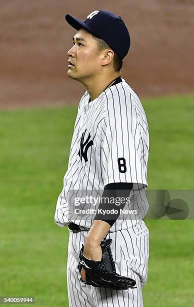 New York Yankees starting pitcher Masahiro Tanaka reacts after allowing a three-run home run to Ian Kinsler of the Detroit Tigers in the fifth inning...
