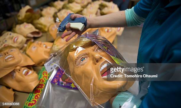 An employee packs a rubber mask in the likeness of Republican presidential candidate Donald Trump at the Ozawa Studios Inc. Factory on June 14, 2016...